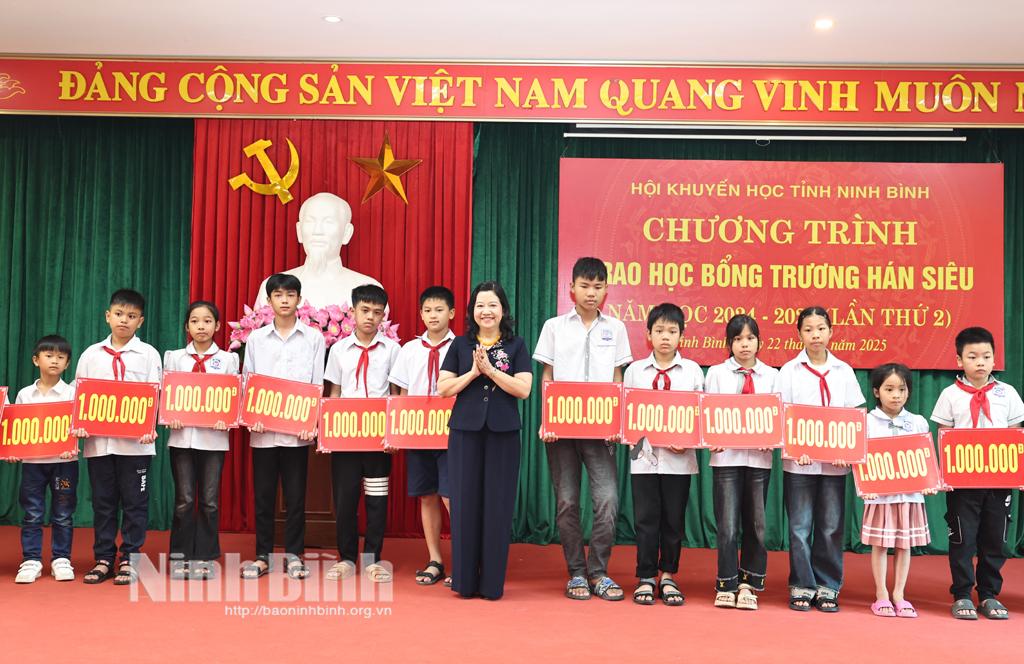 Lãnh đạo Ban Tuyên giáo và Dân vận Tỉnh uỷ trao biển biểu trưng tiền học bổng cho các em học sinh.