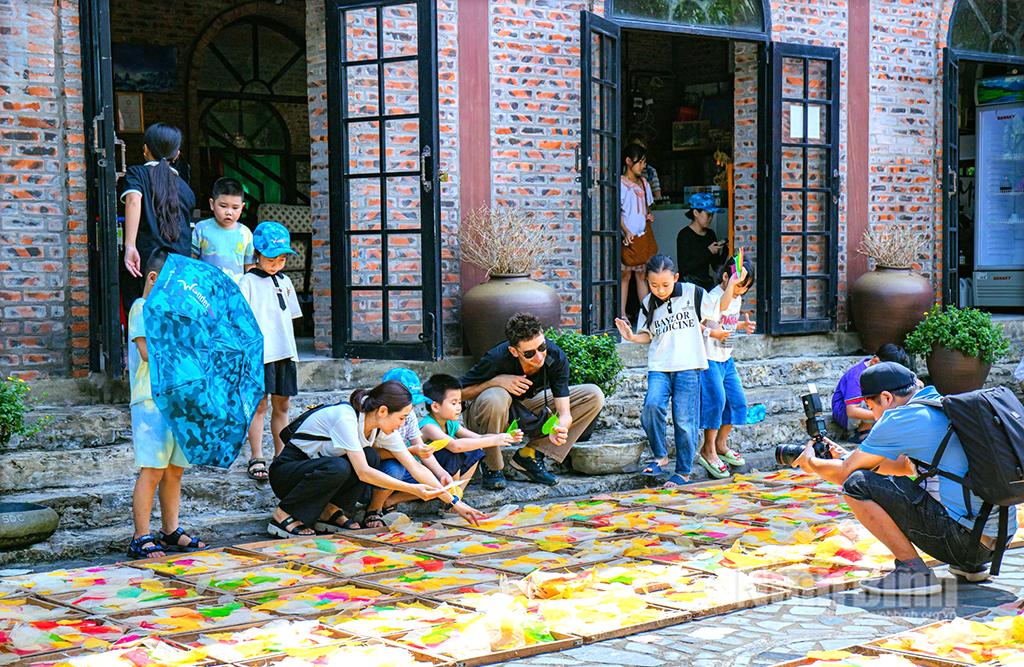 Khách du lịch tham gia hoạt động trải nghiệm phơi lá bồ đề tại Hợp tác xã Sinh Dược. Ảnh: Lan Anh