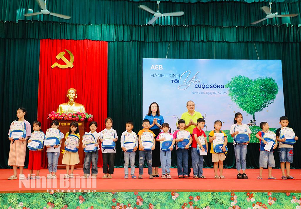 Đại diện lãnh đạo Tỉnh đoàn và nhà tài trợ trao quà cho các em học sinh.