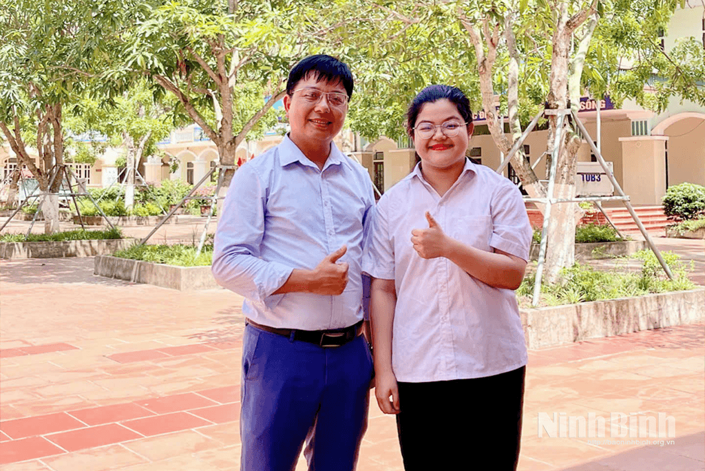 Em An và thầy chủ nhiệm chụp ảnh lưu niệm.