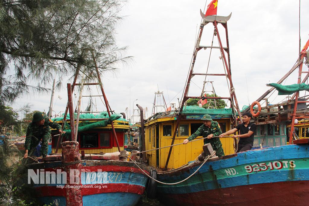 Cán bộ Trạm Biên phòng Cửa khẩu cảng Hải Thịnh hỗ trợ ngư dân chằng buộc tàu thuyền bảo đảm an toàn trước mưa bão.