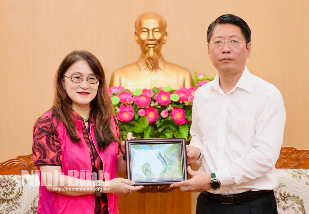 Đồng chí Trần Song Tùng, Ủy viên Ban Thường vụ Tỉnh ủy, Phó Chủ tịch Thường trực UBND tỉnh tặng bức tranh phong cảnh Ninh Bình cho bà Agatha Anne Bunanta - Phó Chủ tịch Quan hệ Đối ngoại của Hiệp hội Nhiếp ảnh Hoa Kỳ.