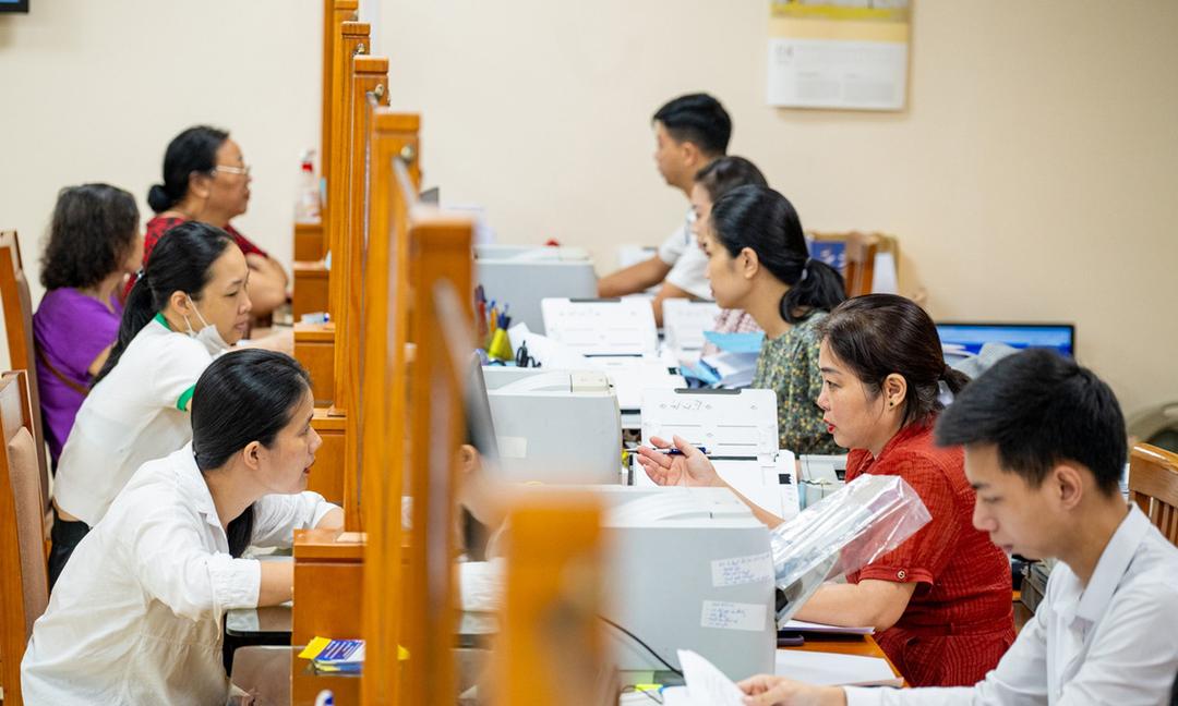 Công chức phường ở Hà Nội hỗ trợ người dân giải quyết thủ tục hành chính. (Ảnh: TTXVN)