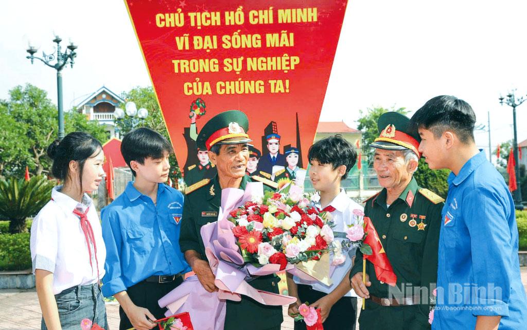 Cựu chiến binh phường Lê Hồ trò chuyện với các cháu thanh, thiếu niên nhân dịp về dự Đại hội Đảng bộ phường lần thứ I.