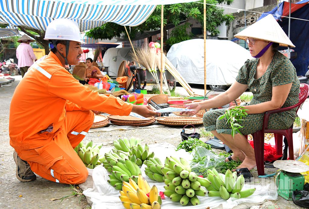 Nhân viên Công ty Điện lực Ninh Bình phát tờ rơi hướng dẫn khách hàng các phương thức thanh toán tiền điện mới. Ảnh: Trường Giang