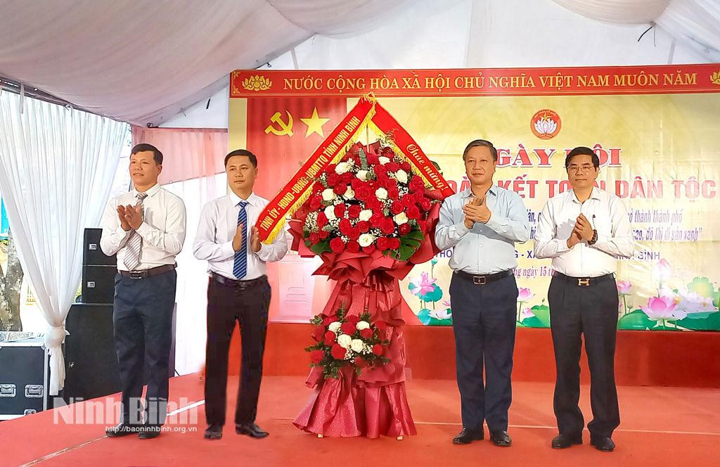 Đồng chí Đinh Việt Dũng, Ủy viên Ban Thường vụ Tỉnh ủy, Trưởng Ban Tổ chức Tỉnh ủy tặng hoa chúc mừng Ngày hội Đại đoàn kết toàn dân tộc tại thôn Tập Thượng, xã Bình Mỹ.