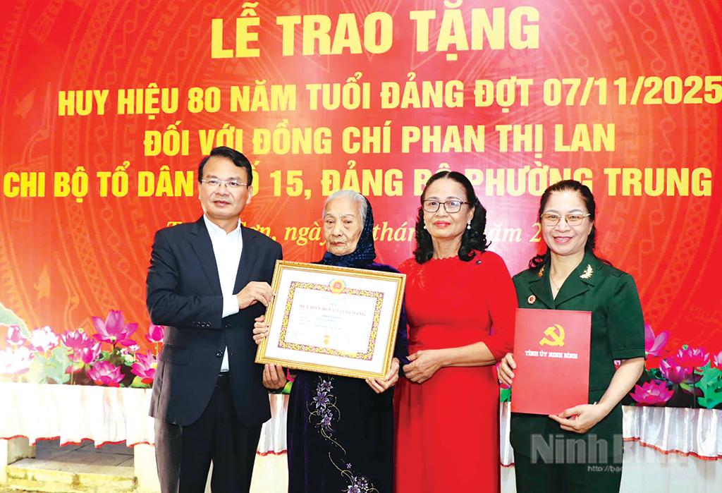 Đồng chí Đặng Xuân Phong, Ủy viên Trung ương Đảng, Bí thư Tỉnh ủy, Trưởng Đoàn đại biểu Quốc hội tỉnh trao tặng Huy hiệu 80 năm tuổi Đảng cho đảng viên Phan Thị Lan (thứ 2 từ trái sang), Chi bộ Tổ dân phố 15, phường Trung Sơn. Ảnh: Đức Lam