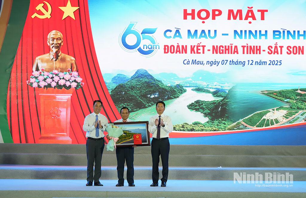 Đồng chí Chủ tịch UBND tỉnh Cà Mau Lữ Quang Ngời và đồng chí Trần Song Tùng, Ủy viên Ban Thường vụ Tỉnh ủy, Phó Chủ tịch Thường trực UBND tỉnh Ninh Bình trao tặng vật phẩm lưu niệm cho đại diện Ban Liên lạc đồng hương Ninh Bình tại tỉnh Cà Mau.