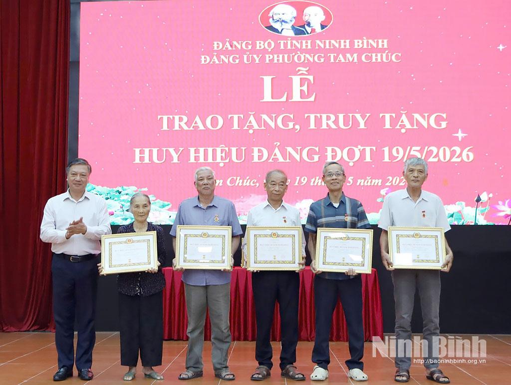 Đồng chí Đinh Việt Dũng, Ủy viên Ban Thường vụ Tỉnh ủy, Trưởng Ban Tổ chức Tỉnh ủy trao Huy hiệu Đảng cho các đảng viên phường Tam Chúc. Ảnh: Nguyễn Oanh