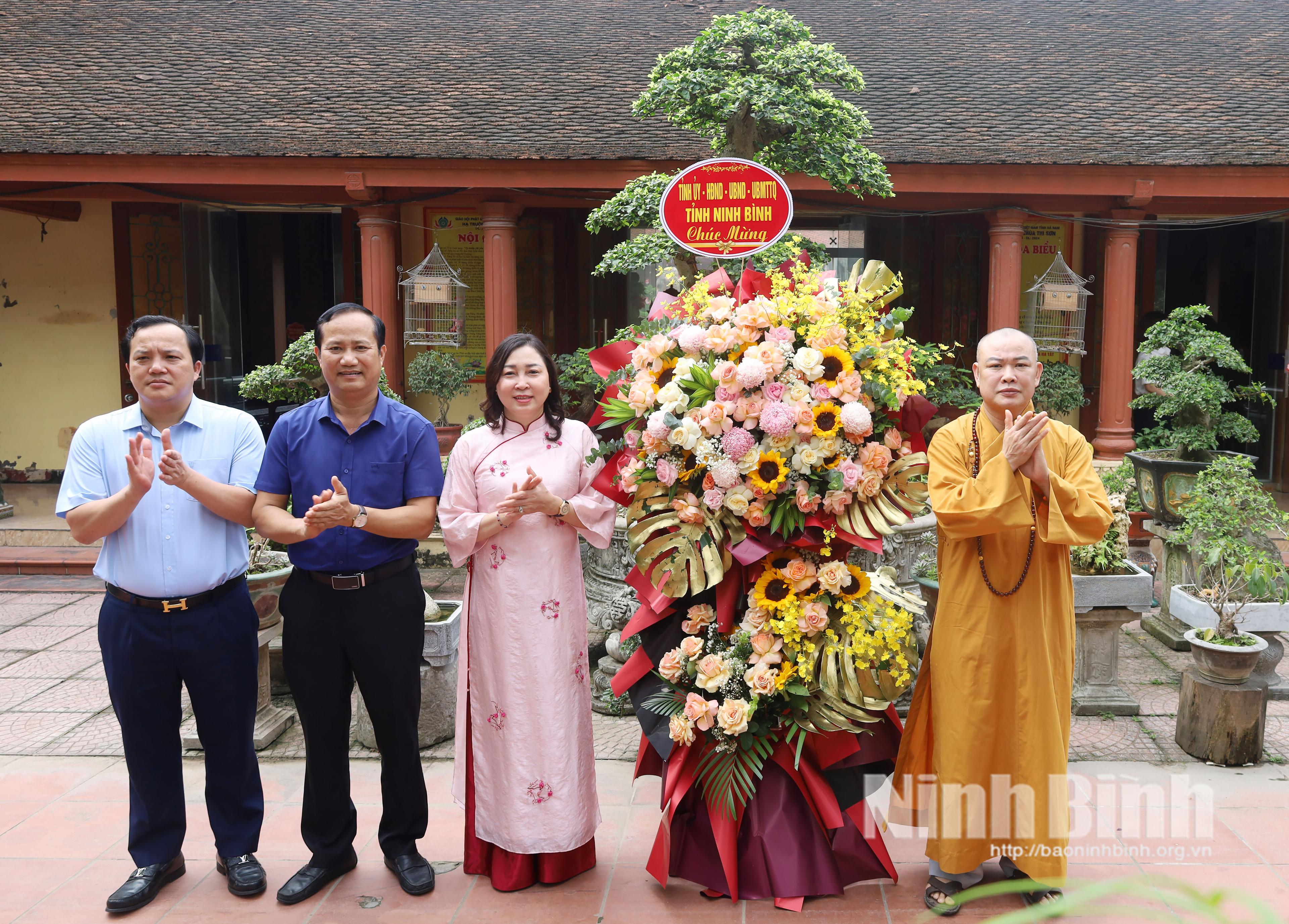 Đồng chí Đinh Thị Lụa, Phó Bí thư Tỉnh ủy, Chủ tịch Ủy ban MTTQ Việt Nam tỉnh tặng hoa chúc mừng chùa Thi Sơn nhân dịp Đại lễ Phật đản 2026.