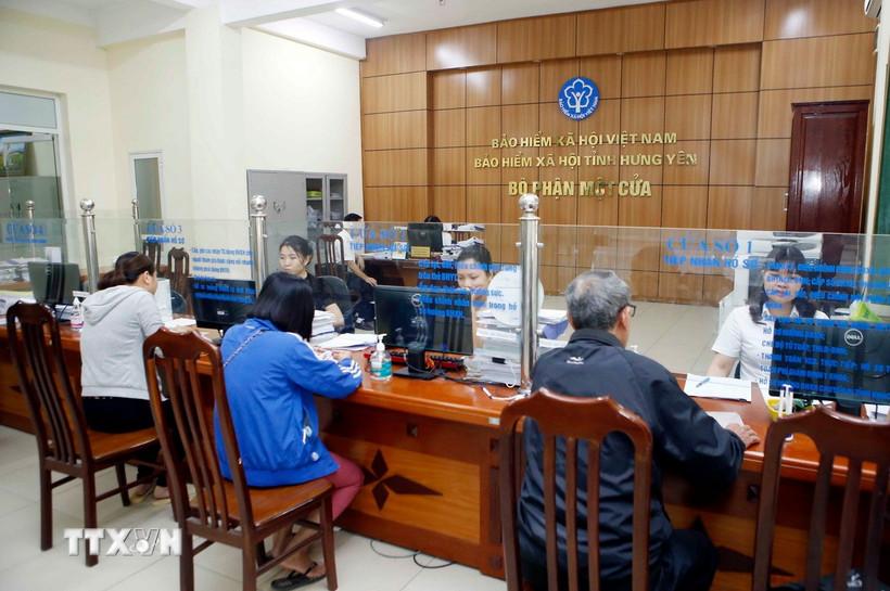 Nhân viên Bảo hiểm Xã hội tỉnh Hưng Yên hướng dẫn người dân làm thủ tục tham gia Bảo hiểm xã hội. (Ảnh: TTXVN)
