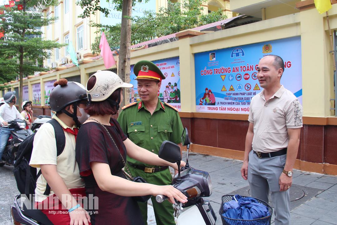 Công an phường Nam Định phối hợp với giáo viên Trường Tiểu học Phạm Hồng Thái tuyên truyền tới phụ huynh, học sinh các quy định nhằm bảo đảm ATGT tại khu vực cổng trường.