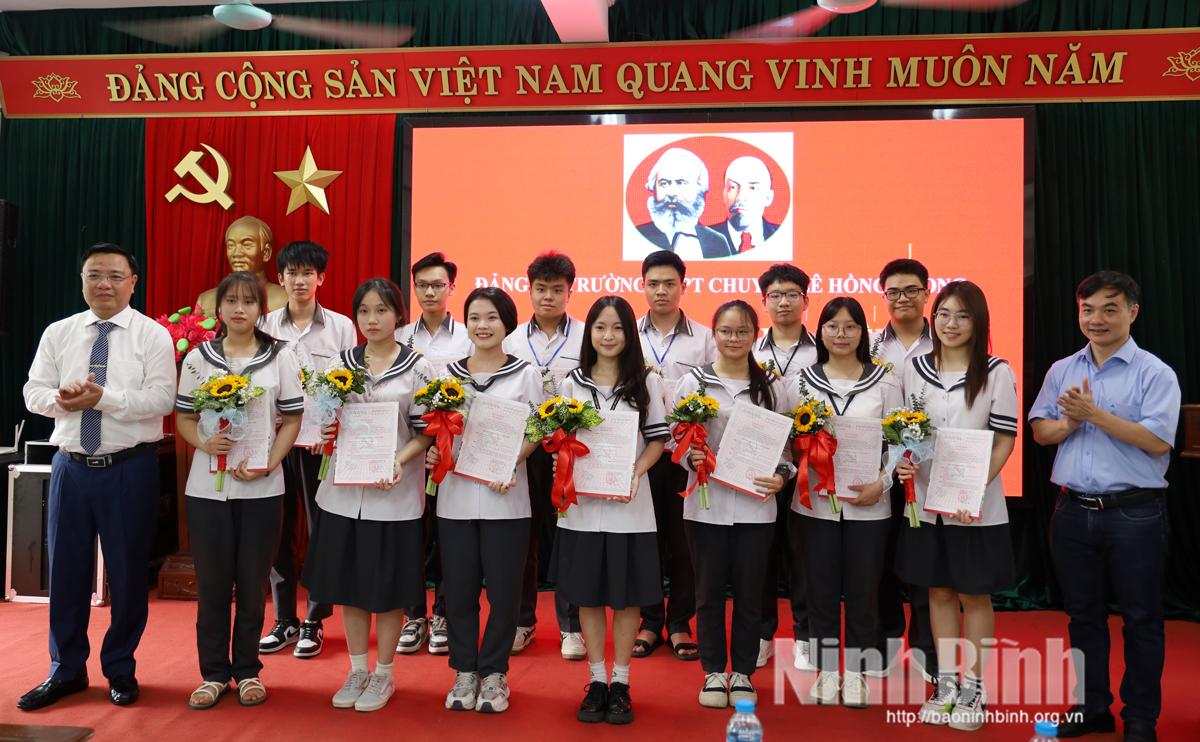 Lãnh đạo nhà trường tặng hoa chúc mừng các đảng viên mới được kết nạp.