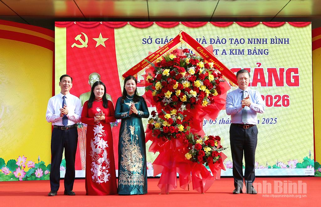 Đồng chí Đinh Việt Dũng, Ủy viên Ban Thường vụ Tỉnh ủy, Trưởng Ban Tổ chức Tỉnh ủy tặng hoa chúc mừng thầy và trò Trường THPT A Kim Bảng. Ảnh: Mạnh Hùng