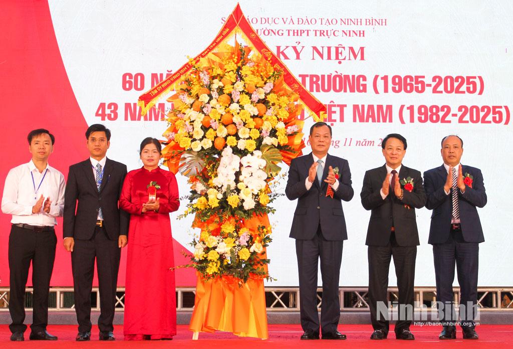 Đồng chí Lê Quốc Chỉnh, Phó Bí thư Tỉnh ủy, Chủ tịch HĐND tỉnh tặng hoa chúc mừng thầy và trò Trường THPT Trực Ninh (xã Cát Thành).