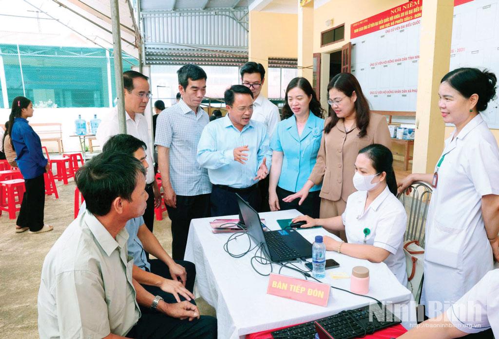 Các đồng chí lãnh đạo tỉnh, lãnh đạo Sở Y tế và xã Phú Long thăm hỏi, động viên người dân đến khám sàng lọc tại Trạm Y tế xã Phú Long. Ảnh: Minh Quang