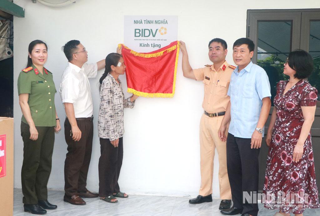 Các đại biểu thực hiện nghi thức gắn biển, trao nhà “Đại doàn kết” cho gia đình bà Trần Thị Mơ.
