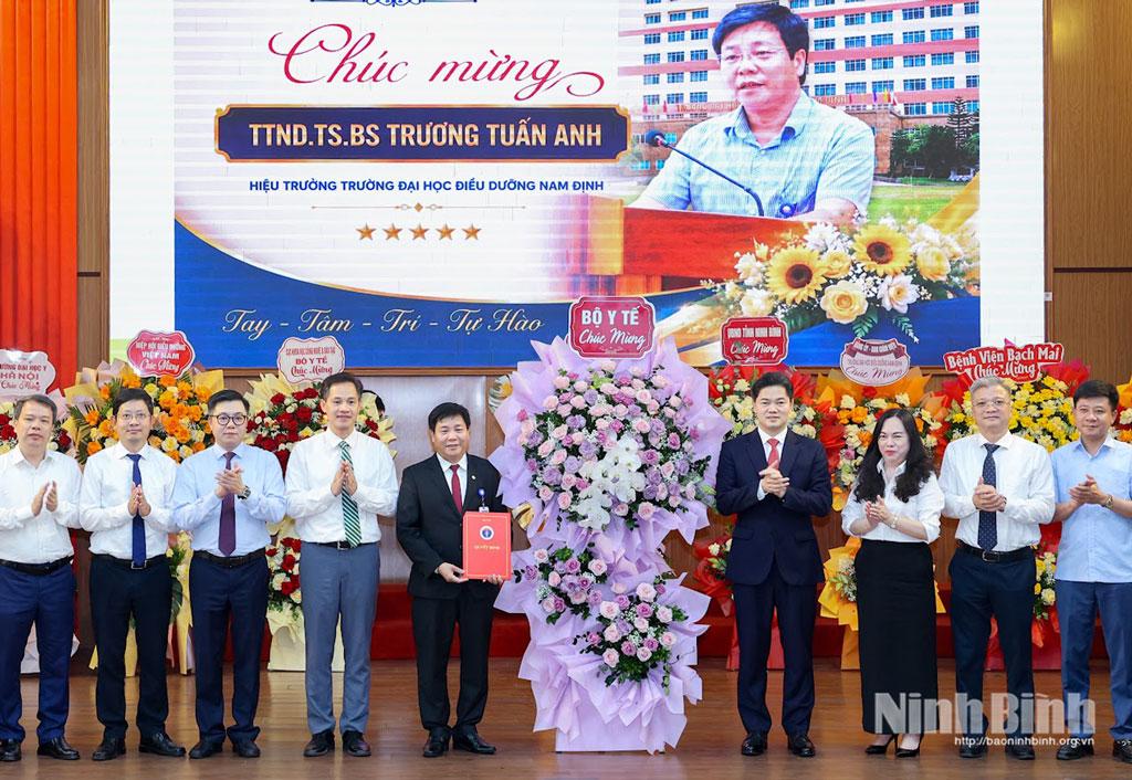 Đồng chí Vũ Mạnh Hà, Ủy viên dự khuyết Trung ương Đảng, Thứ trưởng Thường trực Bộ Y tế và đại diện Bộ Y tế tặng hoa chúc mừng tân Hiệu trưởng.