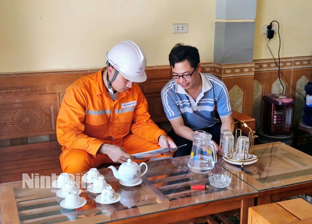 Cán bộ Đội Quản lý điện lực khu vực Lý Nhân tuyên truyền khách hàng thanh toán tiền điện không dùng tiền mặt.