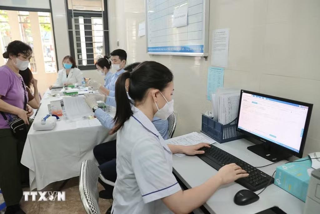 Nhân viên y tế Trạm Y tế phường Bạch Mai cập nhật thông tin, hồ sơ của bệnh nhân lên hệ thống Hồ sơ sức khoẻ điện tử của thành phố. (Ảnh: Minh Quyết/TTXVN)