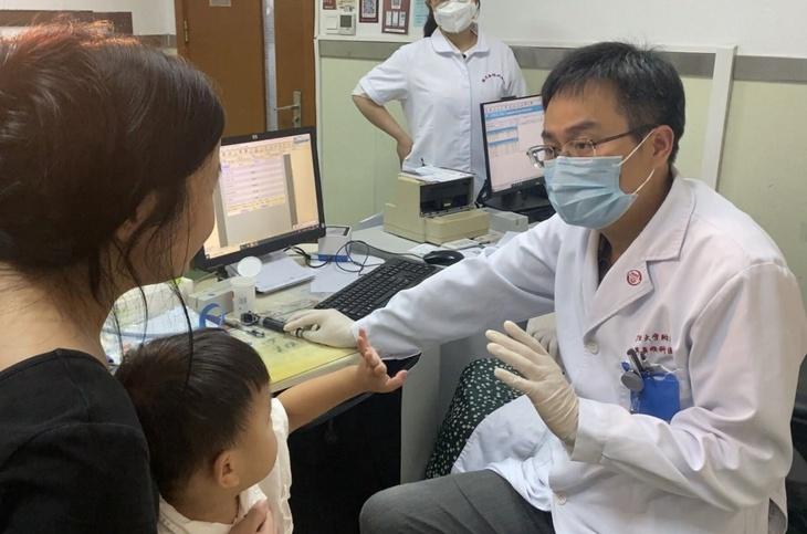 Bác sĩ Shu Yilai đang giao tiếp với một bệnh nhân nhỏ tuổi tại Bệnh viện Mắt và Tai Mũi Họng thuộc Đại học Phúc Đán. Ảnh: masseyeandear.org