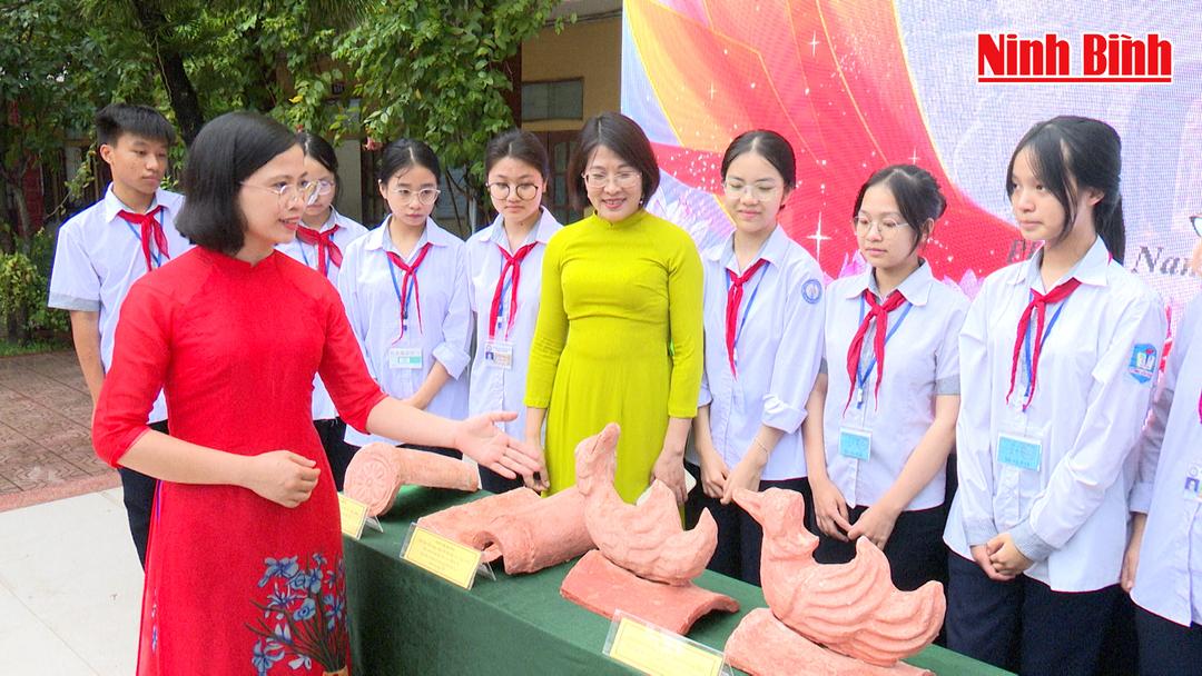 Cán bộ Bảo tàng tỉnh giới thiệu hiện vật cho học sinh Trường THCS Tống Văn Trân (phường Nam Định).